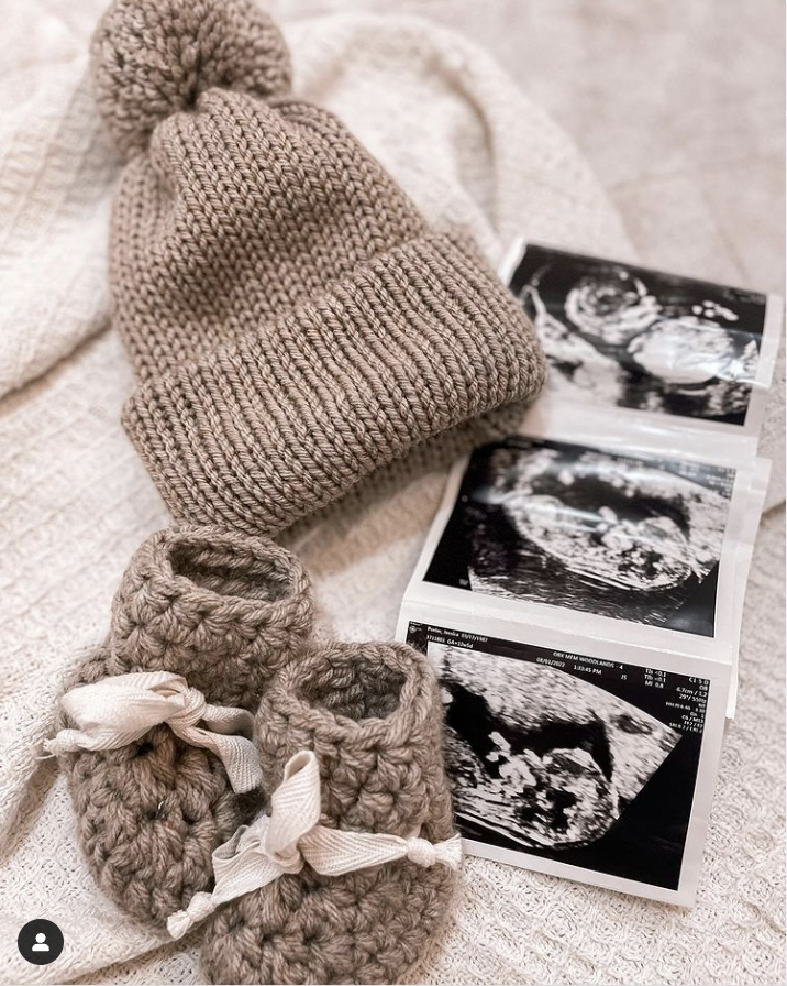 knitted hat and booties  with scan picture in pregnancy announcement 